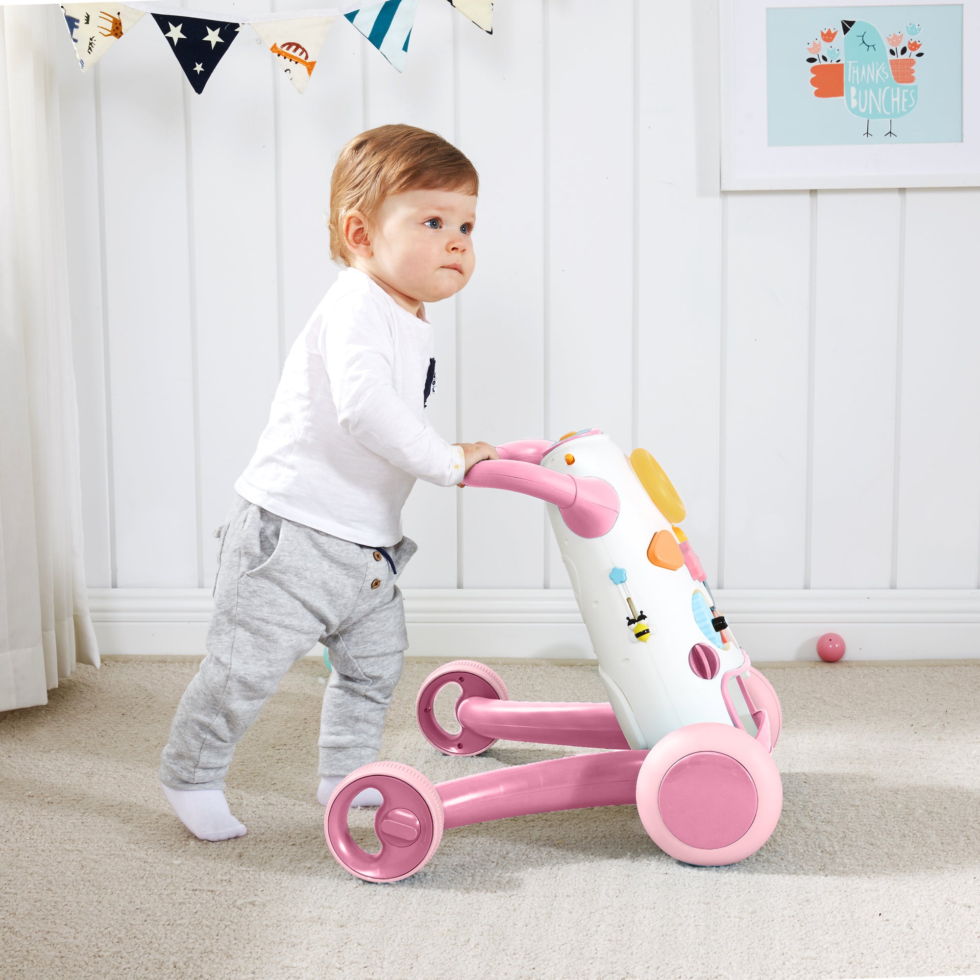 Baby boy pushing the pink KUB baby walker